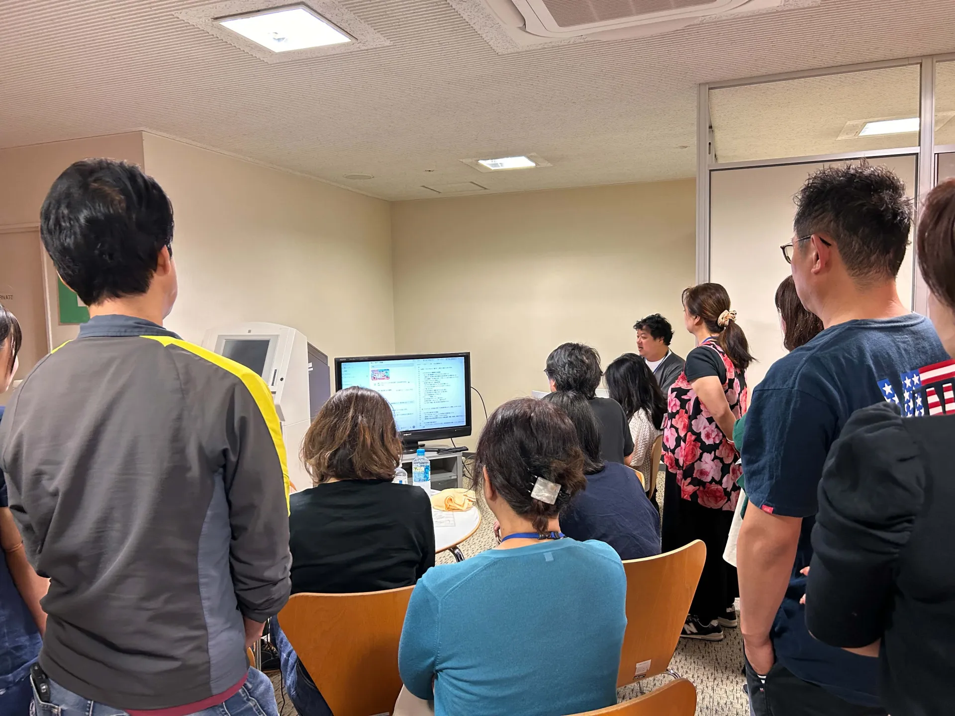 マジリス5の2日目朝、参加者に囲まれて朝ビジの放送準備と本番を実演する長嶺圭一郎
